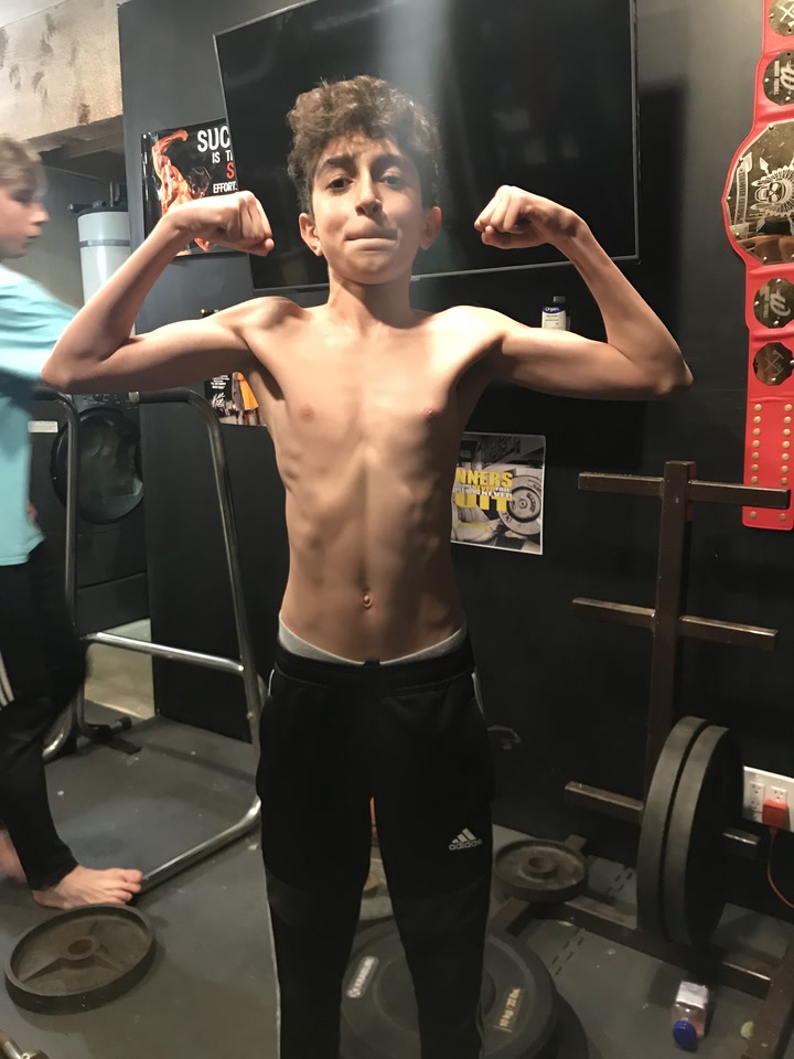 Earlier gym physique photo in a front double-biceps pose